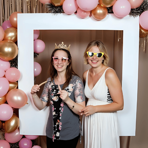Mujeres en un photobooth casero hecho con carton, tela y globos