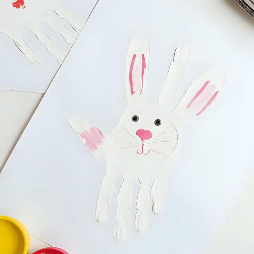 Conejito de pascua pintado con manos en una hoja